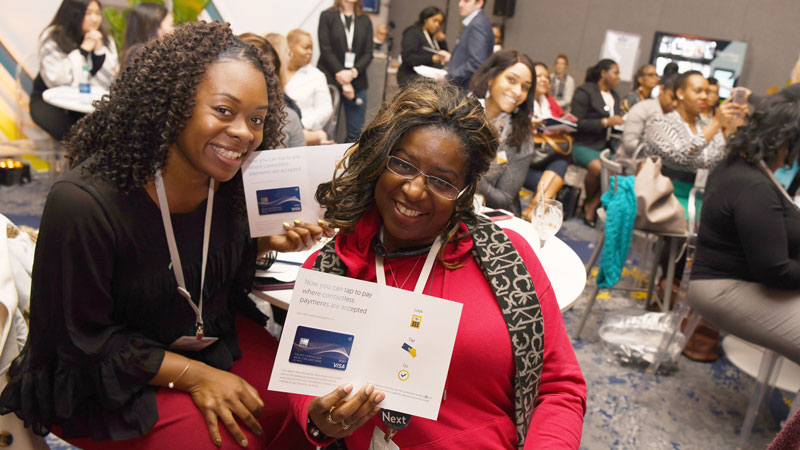 A pair of women smile for the camera at a Visa event