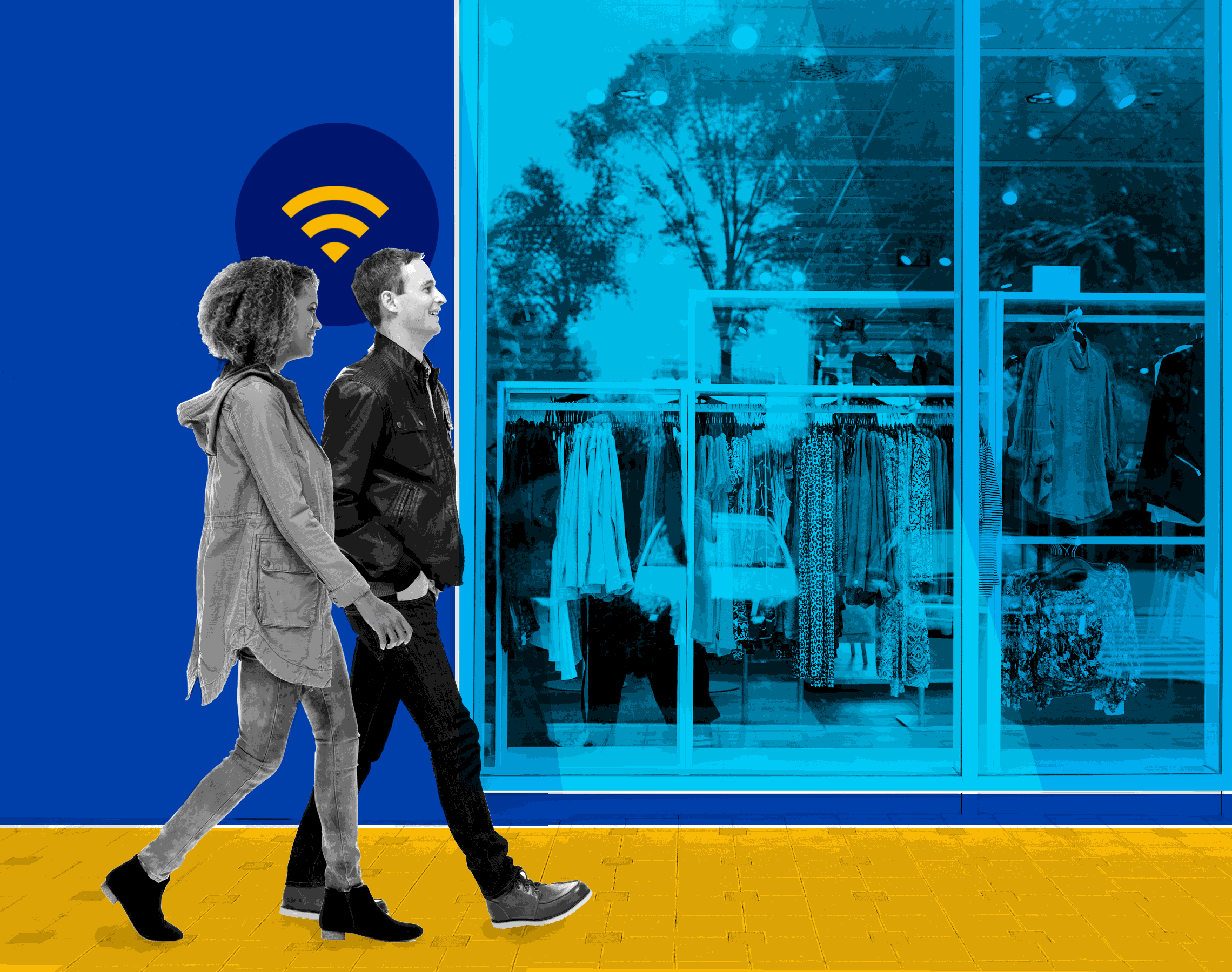 Two people walking down the street in front of a shop