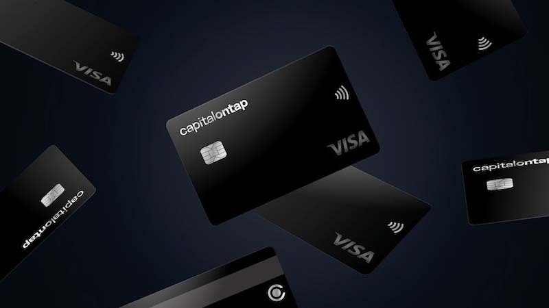 Image of credit cards falling at different angles. Cards have the capitalontap logo, Visa logo, the tap to pay logo, and have embedded chips.