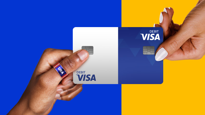 Two hands holding a Visa Debit card.