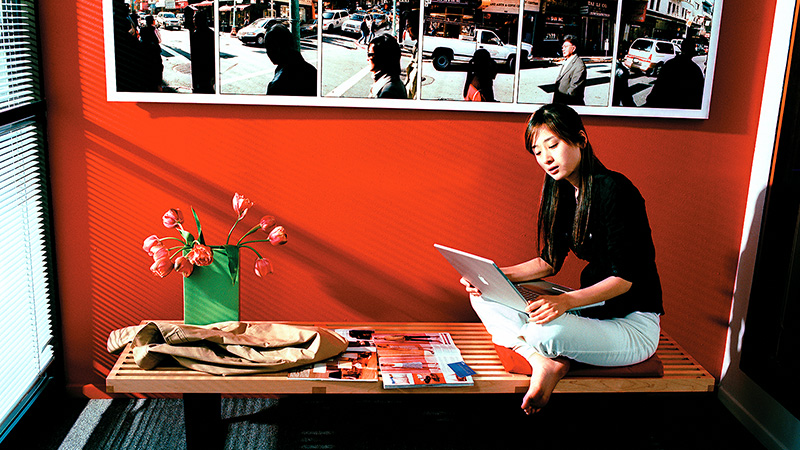 Marquee-VE-KoreanNet-800x450 Young woman using laptop in oriental-style setting.