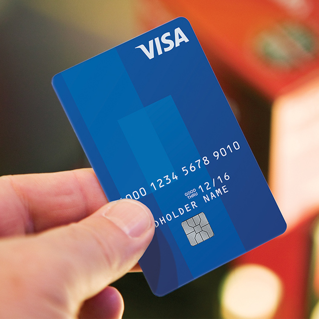Close up of blue Visa Card being held up by a person. Close up of blue Visa Card being held up by a person.