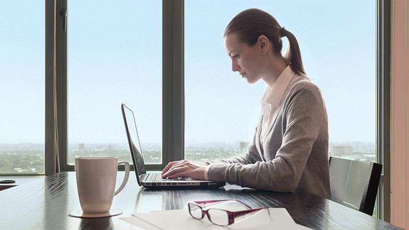 Woman sitting at desk working on computer