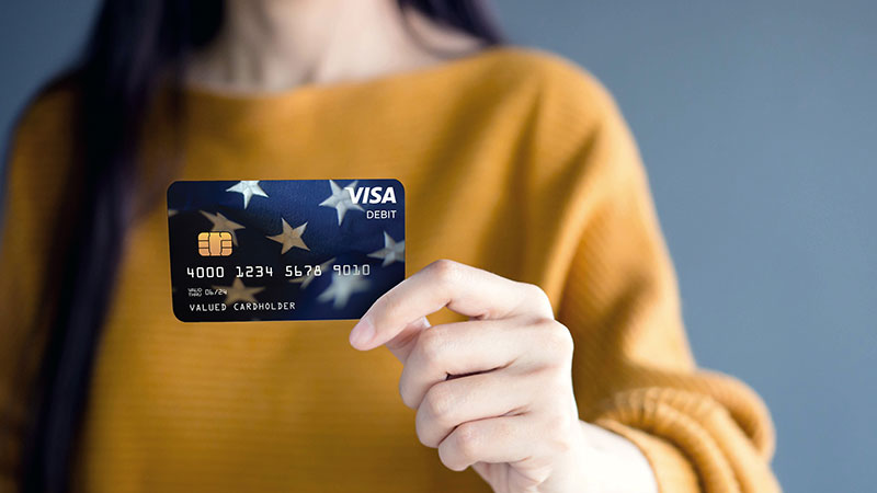 Women holds up a Visa prepaid debit card
