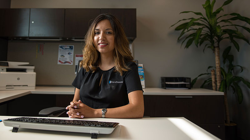 Carmela sitting at a desk in an office.