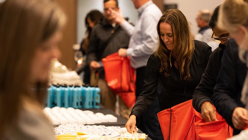 Visa's North America President, Kim Lawrence, puts hygiene products in a bag during a Red Cross kit building event.