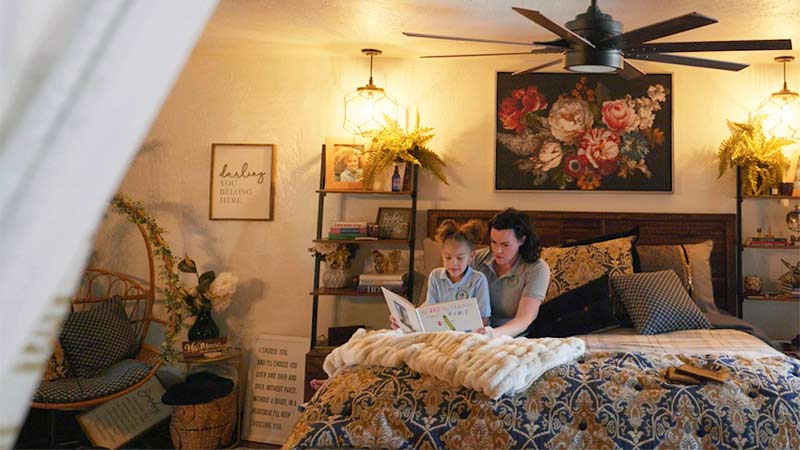 Mother reading to a book to her daughter in bed.