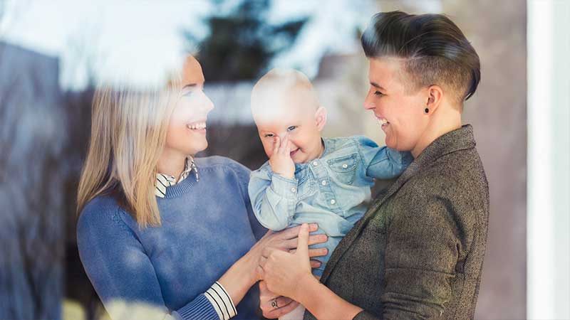 A happy couple holding their giggling baby. A happy couple holding their giggling baby.
