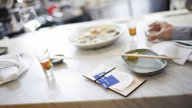 consumer-grocery-spending-800x450 Restaurant table with half empty dishes and a bill with a Visa credit card on top.