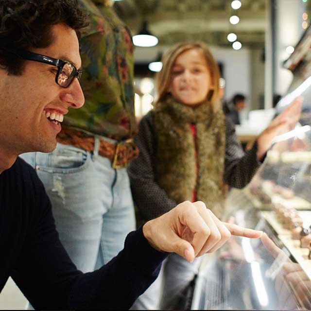 A family looking at pastries through the display glass.