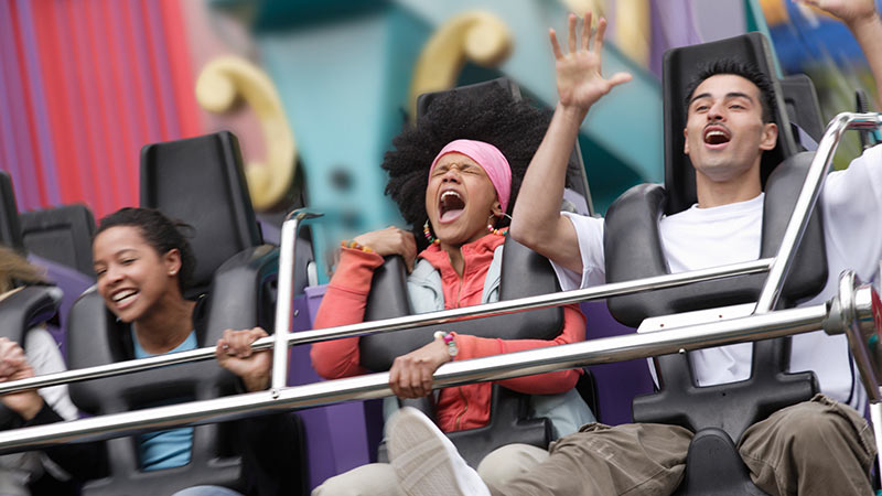 Two women and a man on a rollercoaster Two women and a man on a rollercoaster