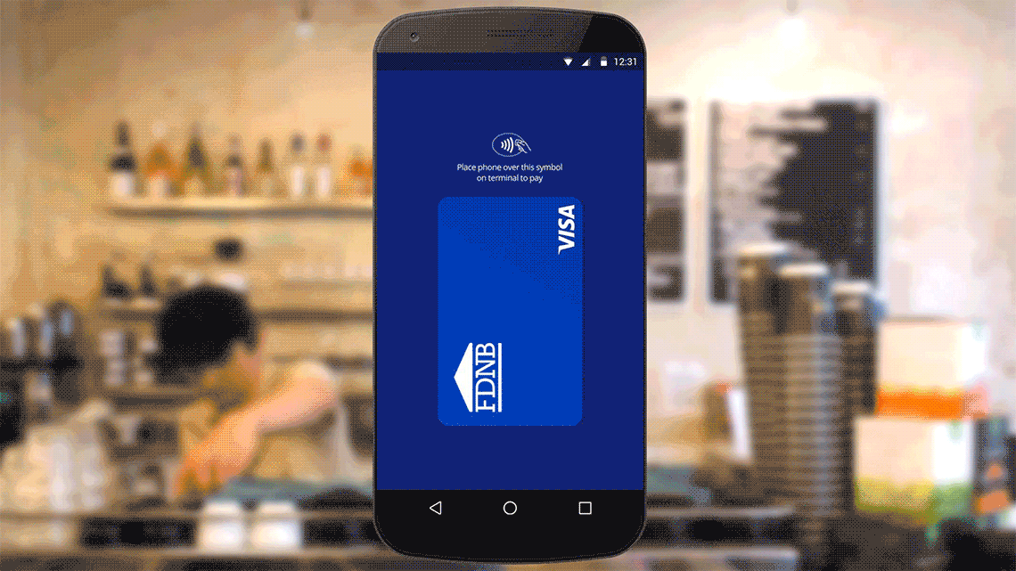 Contactless symbol with instructions and FDNB Visa logo displayed on smart phone superimposed over background of a coffee bar counter.