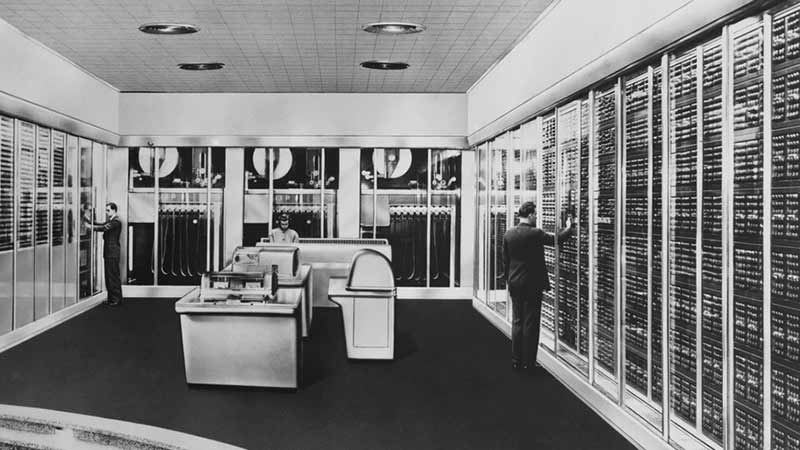 A historical image of employees working in a server room at Visa. A historical image of employees working in a server room at Visa.