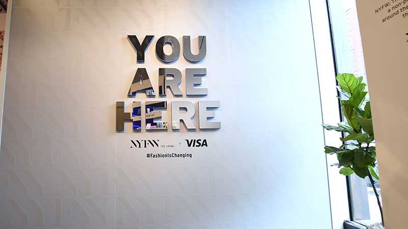 A pop up store wall features a graphic with the words 'You are here'.