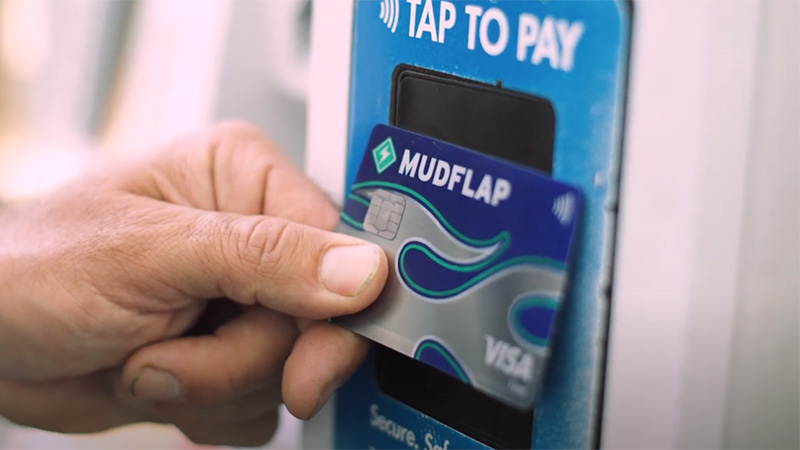 Person using a Visa and Mudflap branded card to tap to pay.