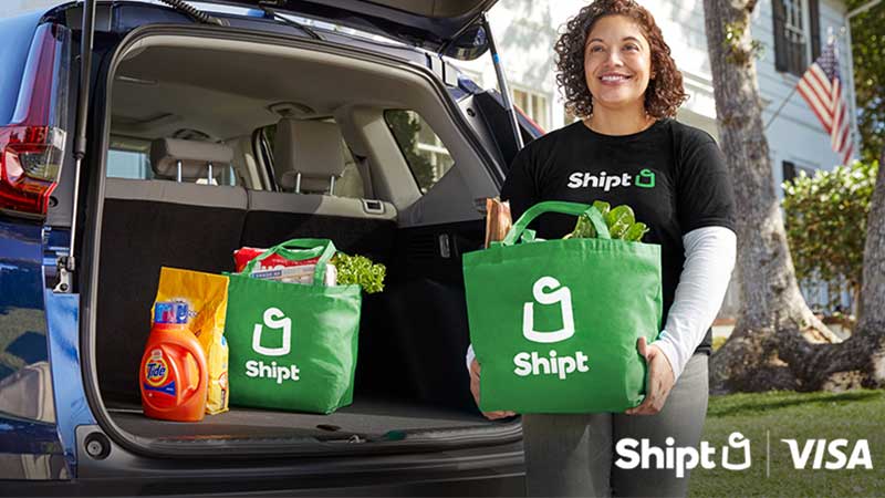 Woman with groceries and the Shipt and Visa logos.