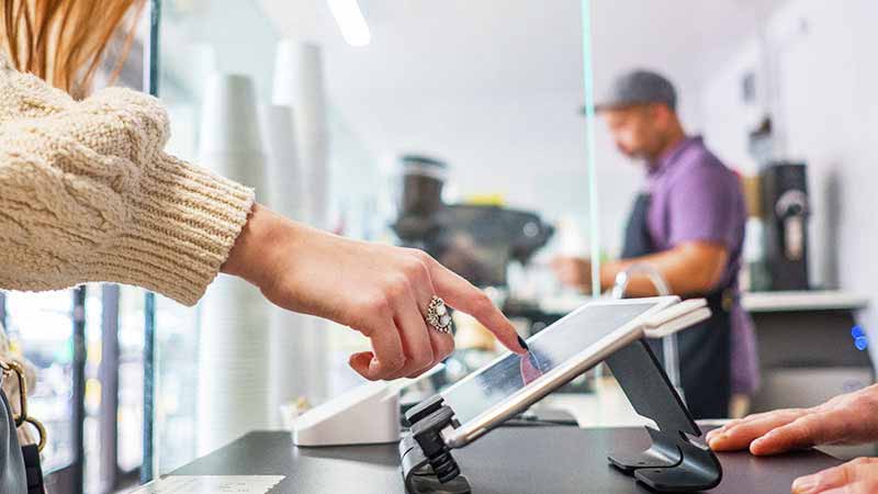 A customer interacting with a tablet to complete a transaction.