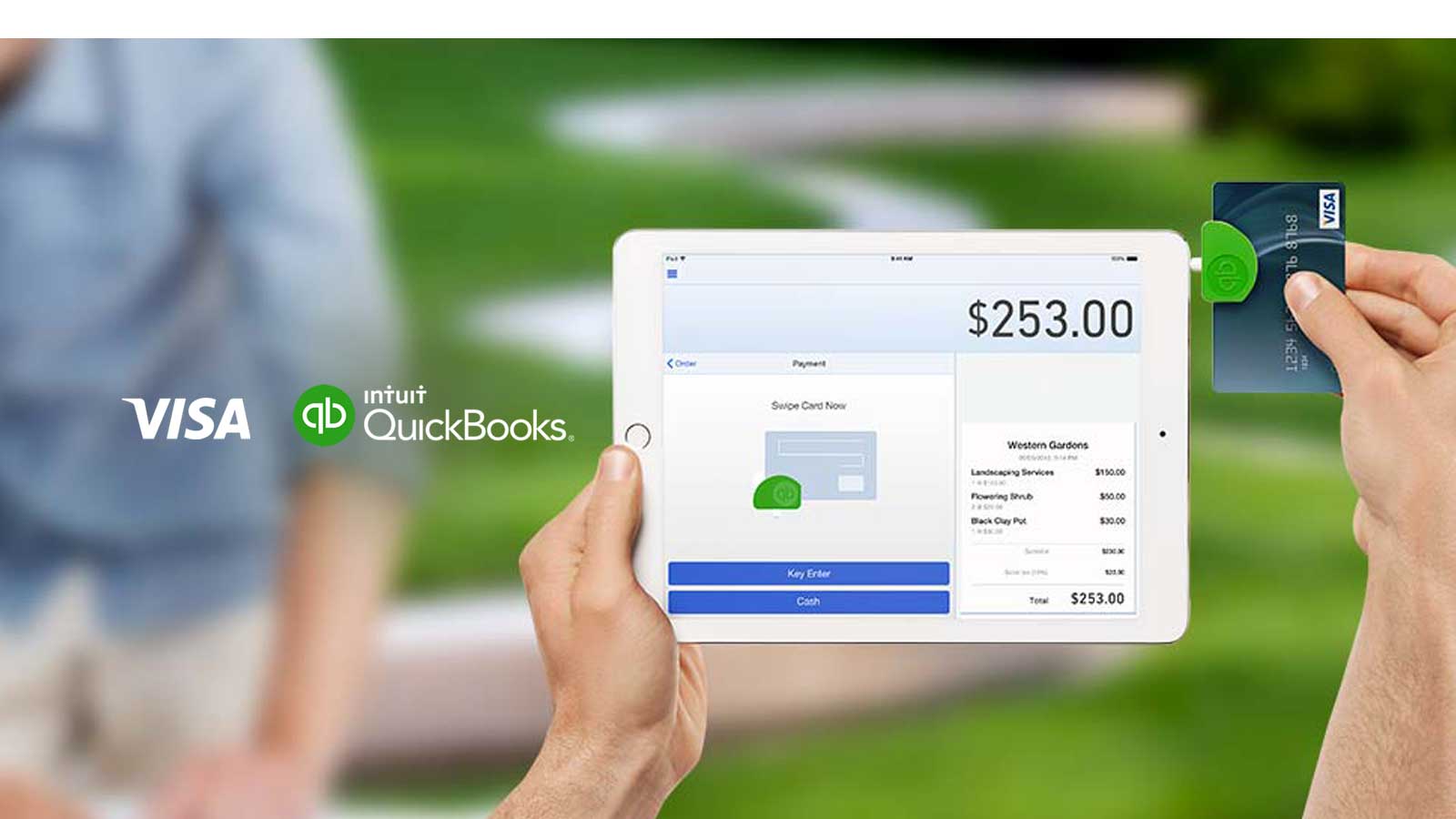 Hand holding an iPad with a Visa card in the card reader