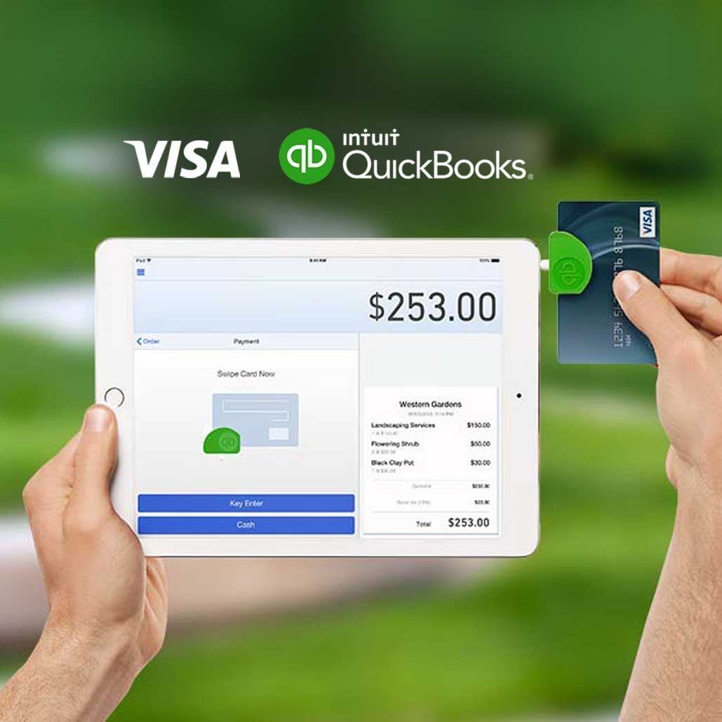 Hand holding an iPad with a Visa card in the card reader